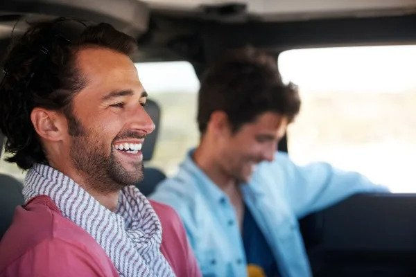 two men smiling in a car
