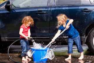 kids with hose washing car